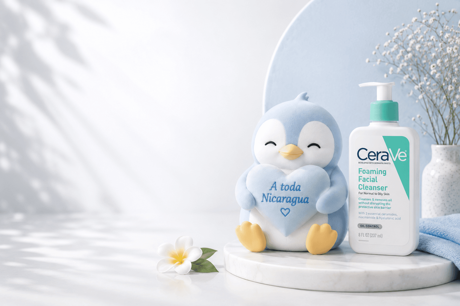 Pingüino de NIMUCARE con corazón celeste junto a un limpiador facial CeraVe en una escena blanca y celeste pastel.
